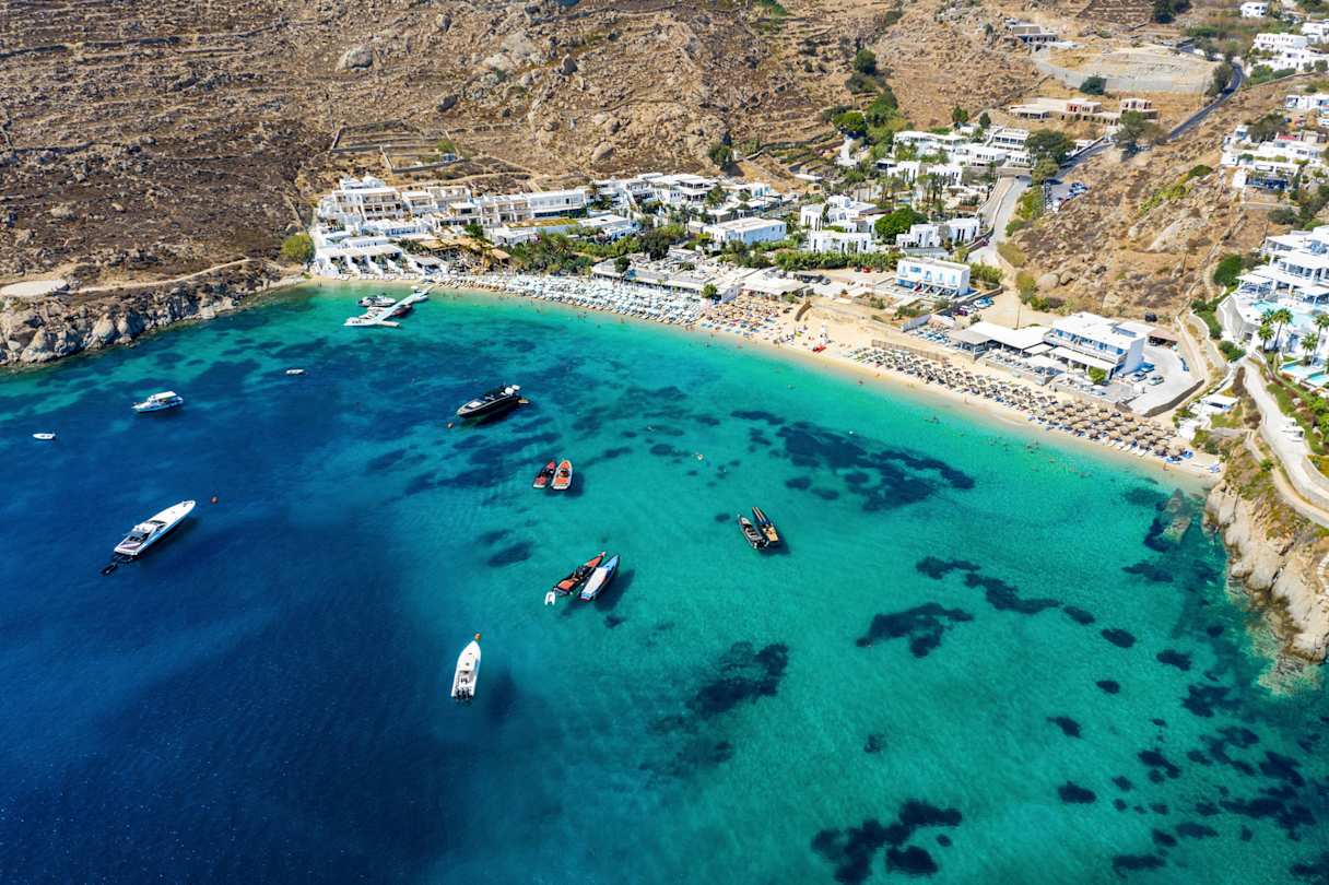 An aerial view of boats on the clear blue water at Psarou Beach, Mykonos, Greece