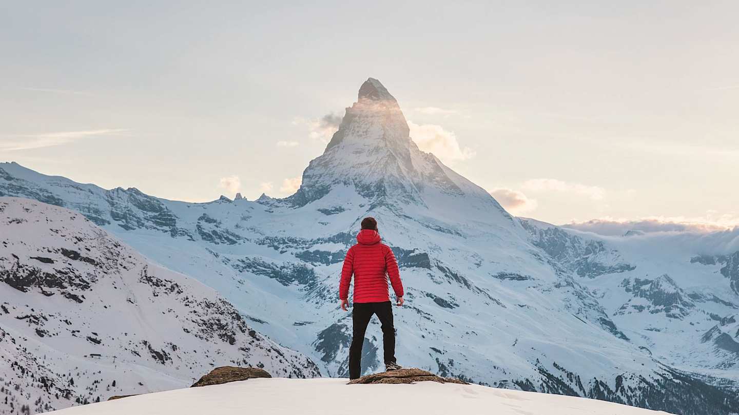 Person standing at the top of a snowy mountain in Zermatt, Switzerland