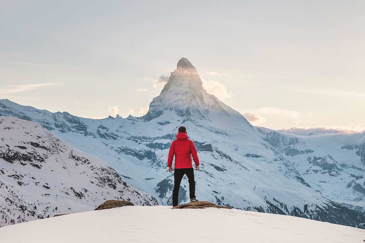 Person standing at the top of a snowy mountain in Zermatt, Switzerland