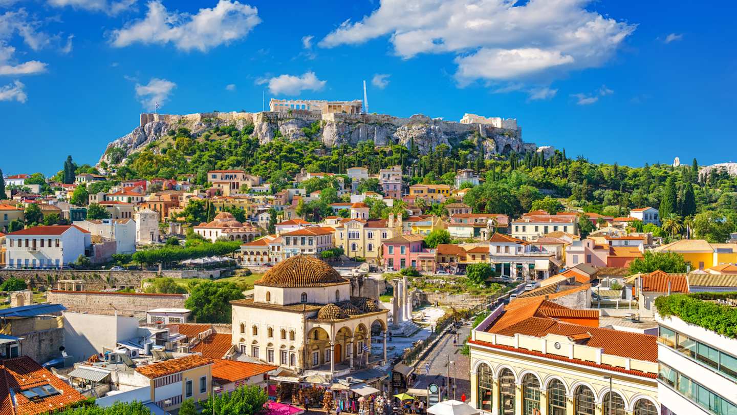 An aerial view of houses and shops in front of the distant Acropolis, Athens, Greece