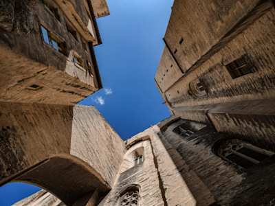 A low-angle view of a tall brown building in Avignon, France on a sunny day