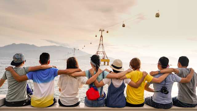 A group of friends sitting together while looking out across the sea