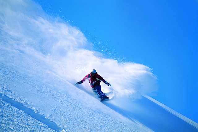 Person snowboarding down a snowy mountain