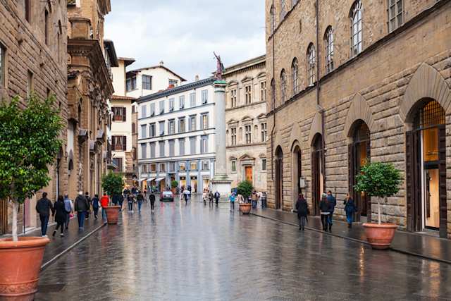 People shopping and walking on the street Via de' Tornabuonion on an autumn rainy day, Florence