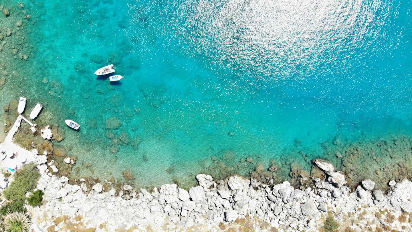 A bird's eye view of white boats in the clear water at St Paul's Bay, Rhodes, Greece