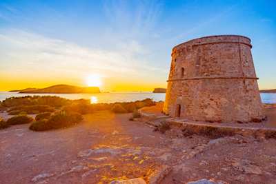 View of ancient watchtower Torre d'en Rovira in Ibiza at sunset