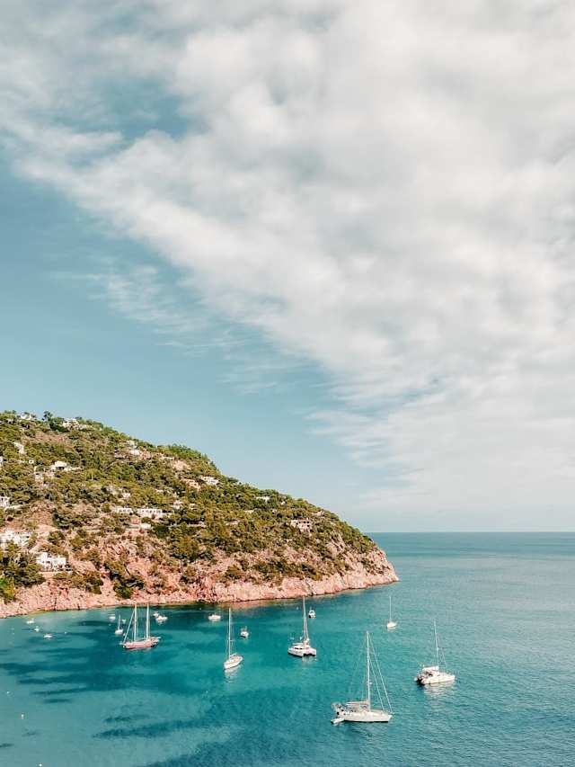 White boats sailing on the blue sea in Ibiza, Spain