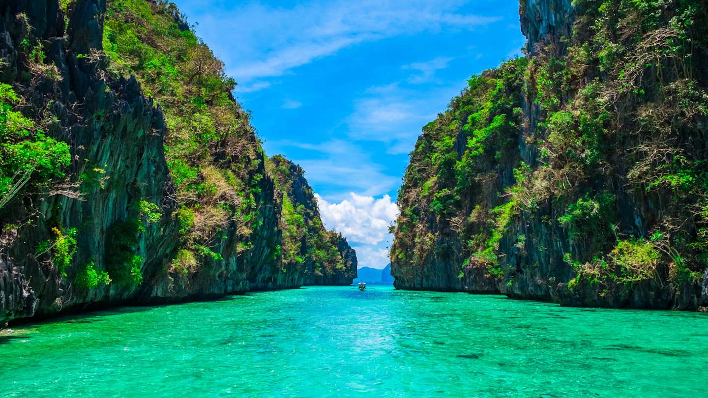 Two large green cliffs beside a narrow blue lagoon, Palawan, Philippines