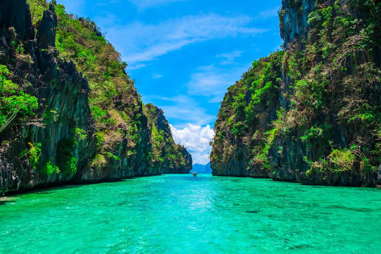 Two large green cliffs beside a narrow blue lagoon, Palawan, Philippines