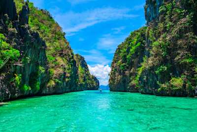 Two large green cliffs beside a narrow blue lagoon, Palawan, Philippines