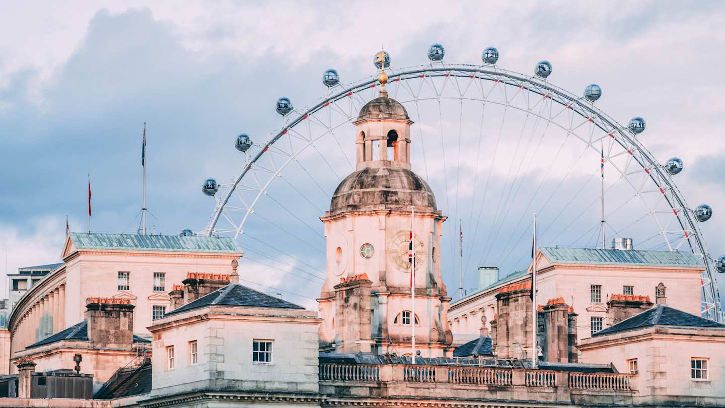 London Eye behind buildings in London