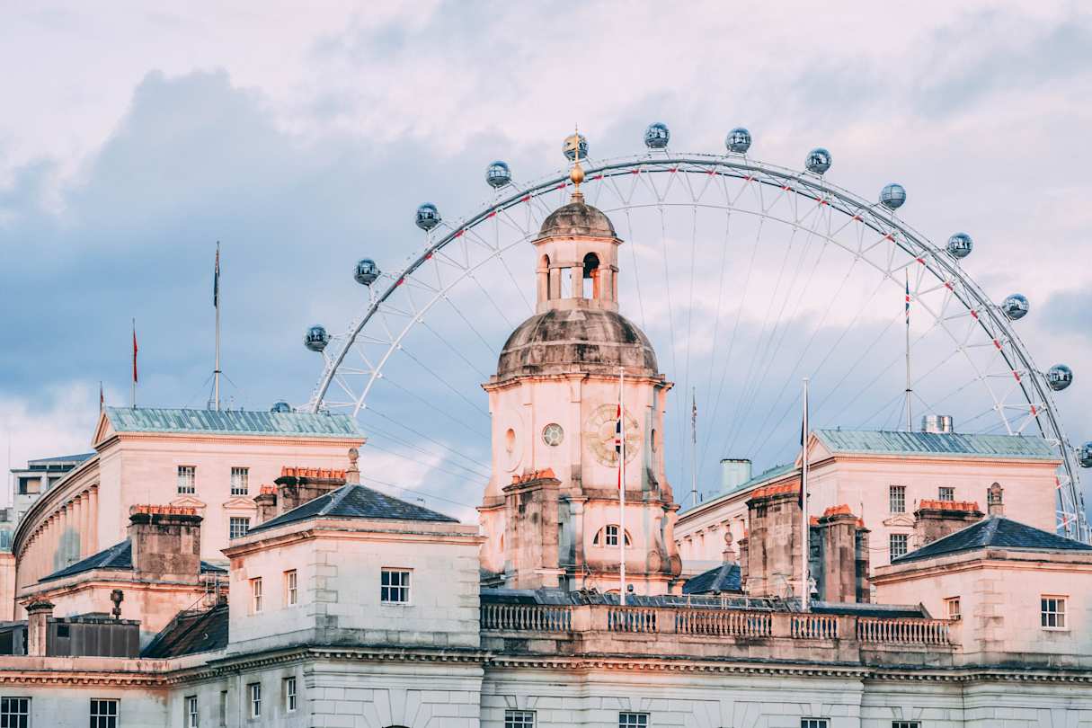 London Eye behind buildings in London