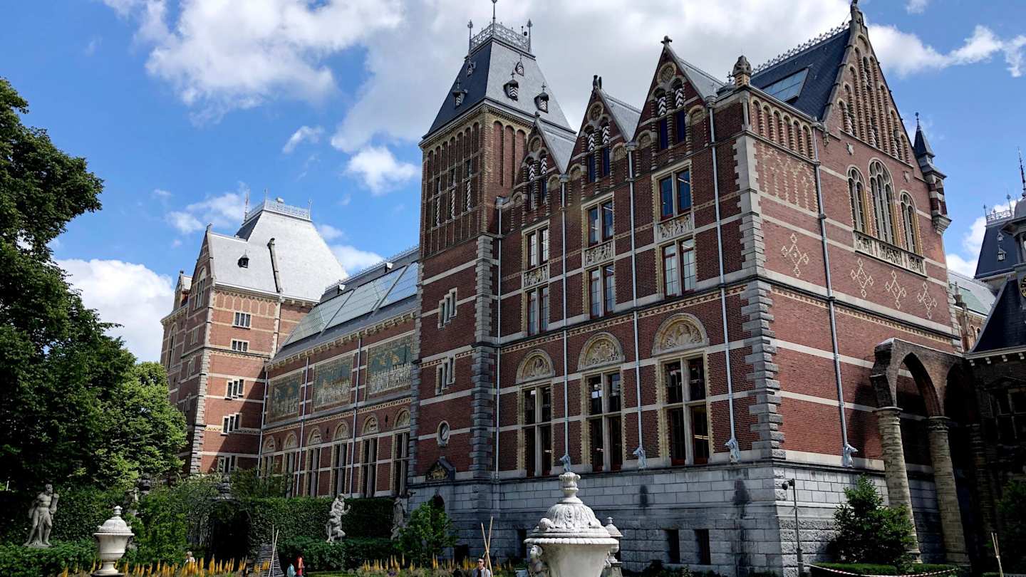 A view of the Rijksmuseum behind a garden area with statues, Amsterdam, Netherlands