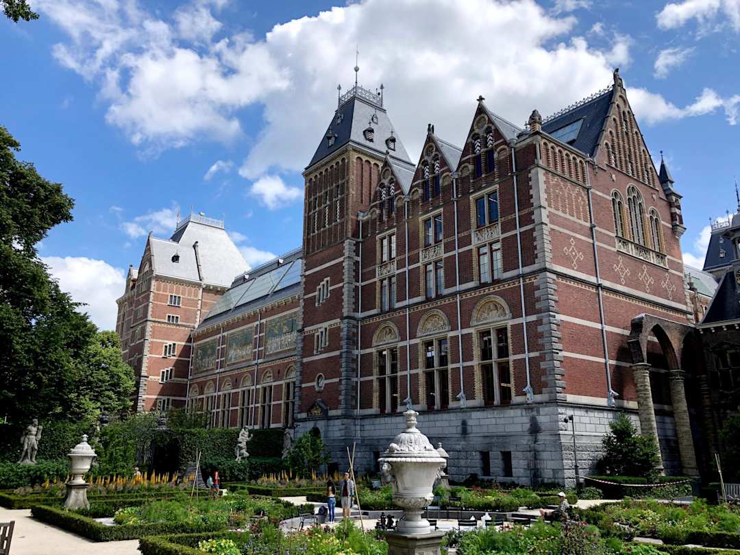 A view of the Rijksmuseum behind a garden area with statues, Amsterdam, Netherlands