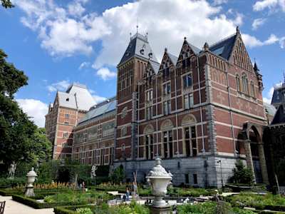 A view of the Rijksmuseum behind a garden area with statues, Amsterdam, Netherlands
