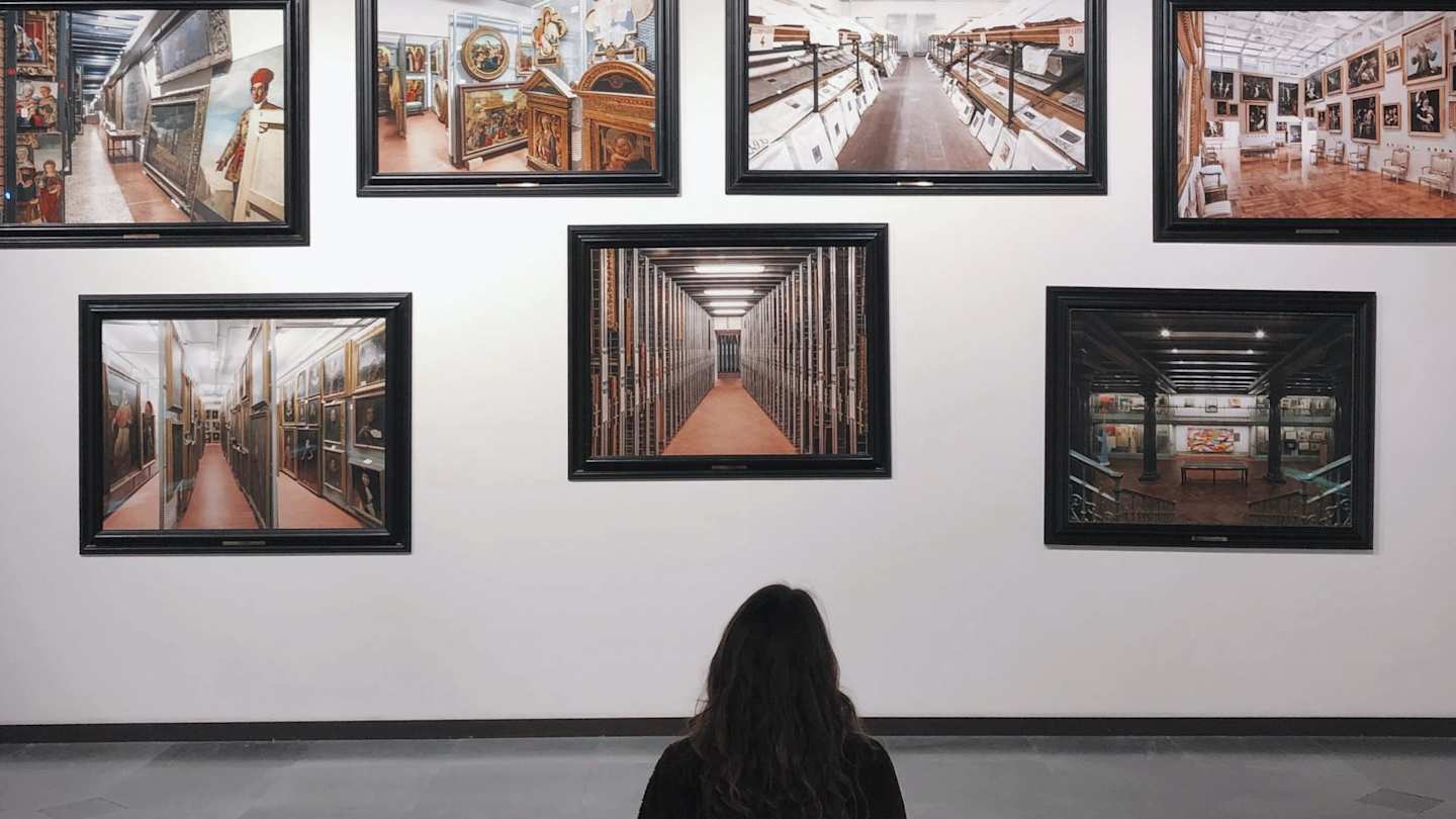 Woman sitting down admiring artwork at an exhibition
