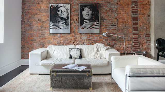 White sofa against exposed brick wall in the living area of Plum Guide home, Cats Cradle