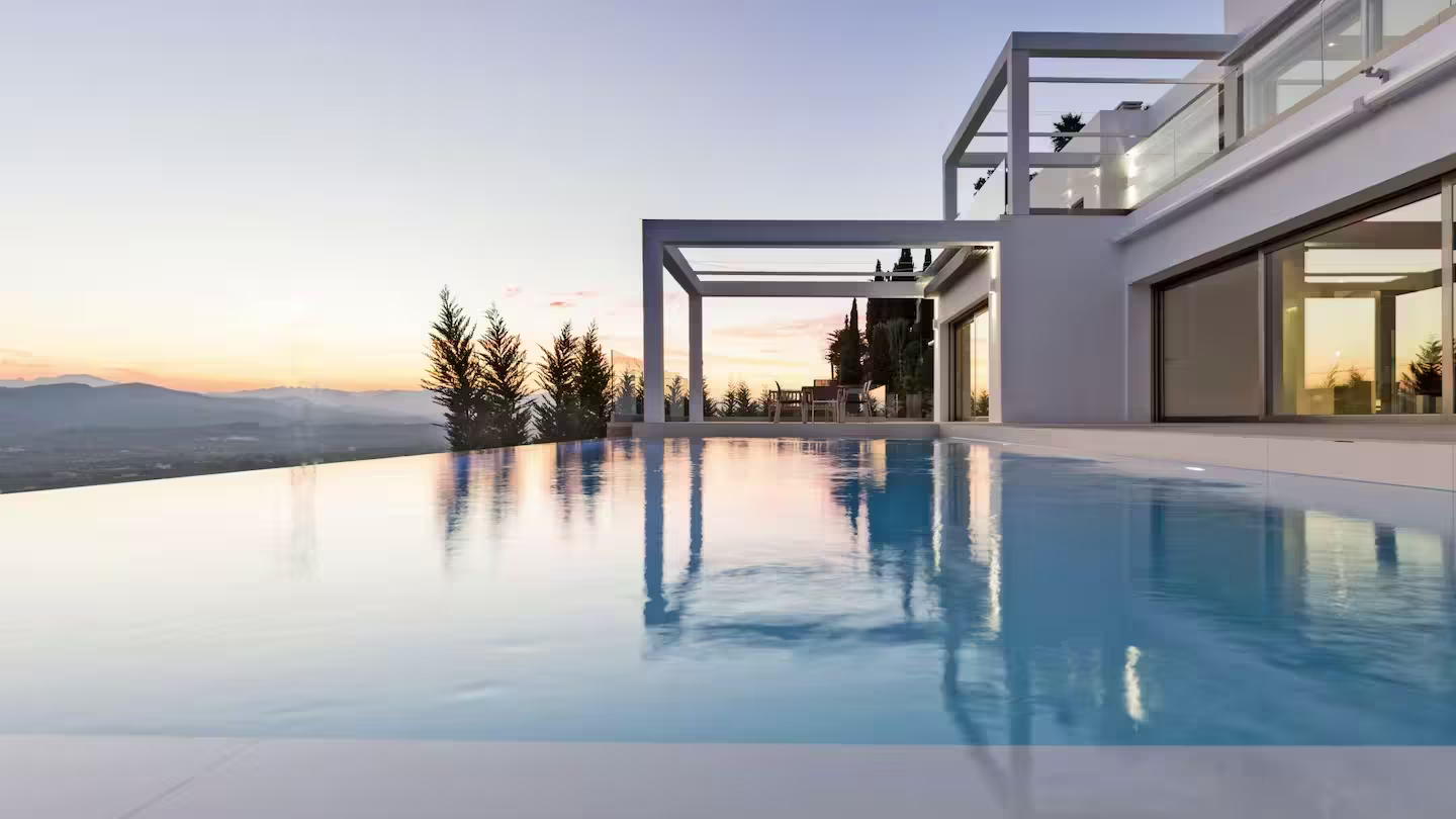 A modern villa at sunset with an infinity pool and mountain views, Plum Guide home Vista Tranquila in Alicante, Spain