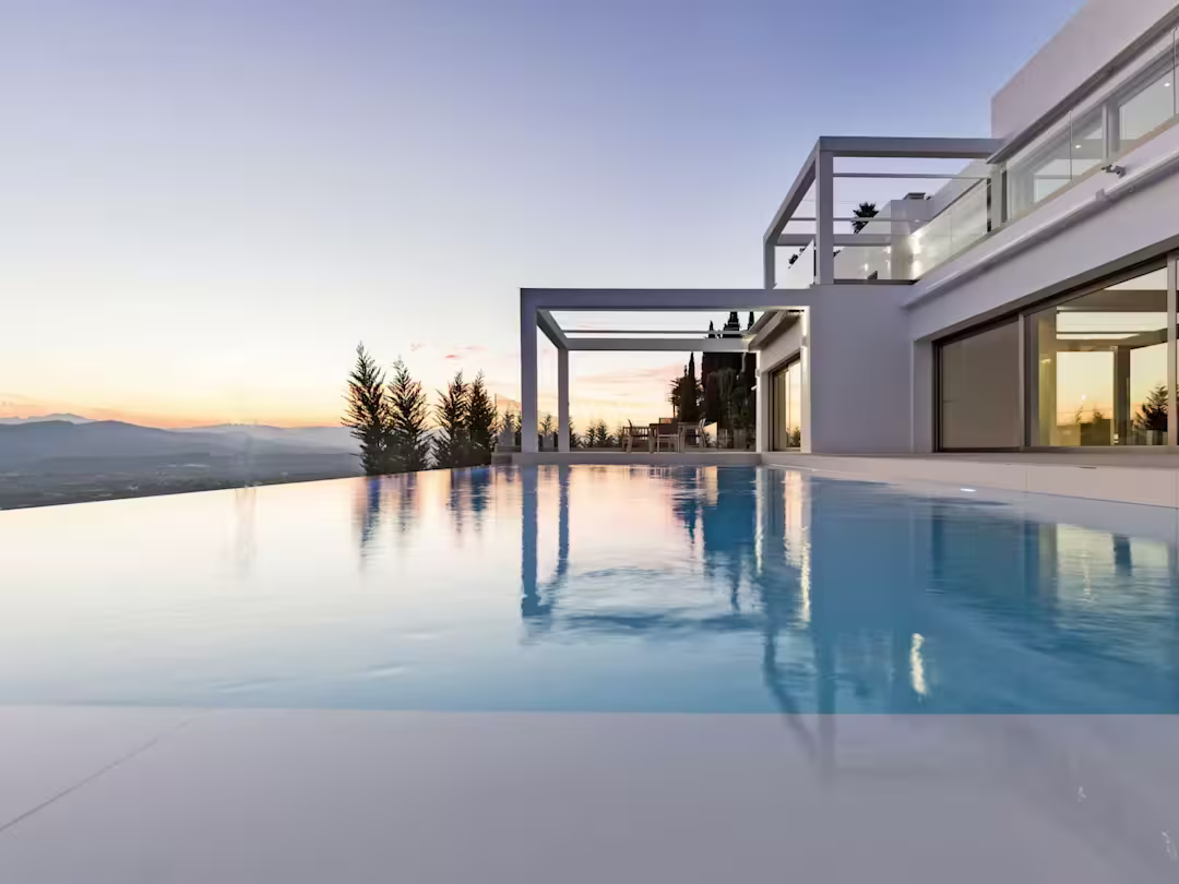 A modern villa at sunset with an infinity pool and mountain views, Plum Guide home Vista Tranquila in Alicante, Spain