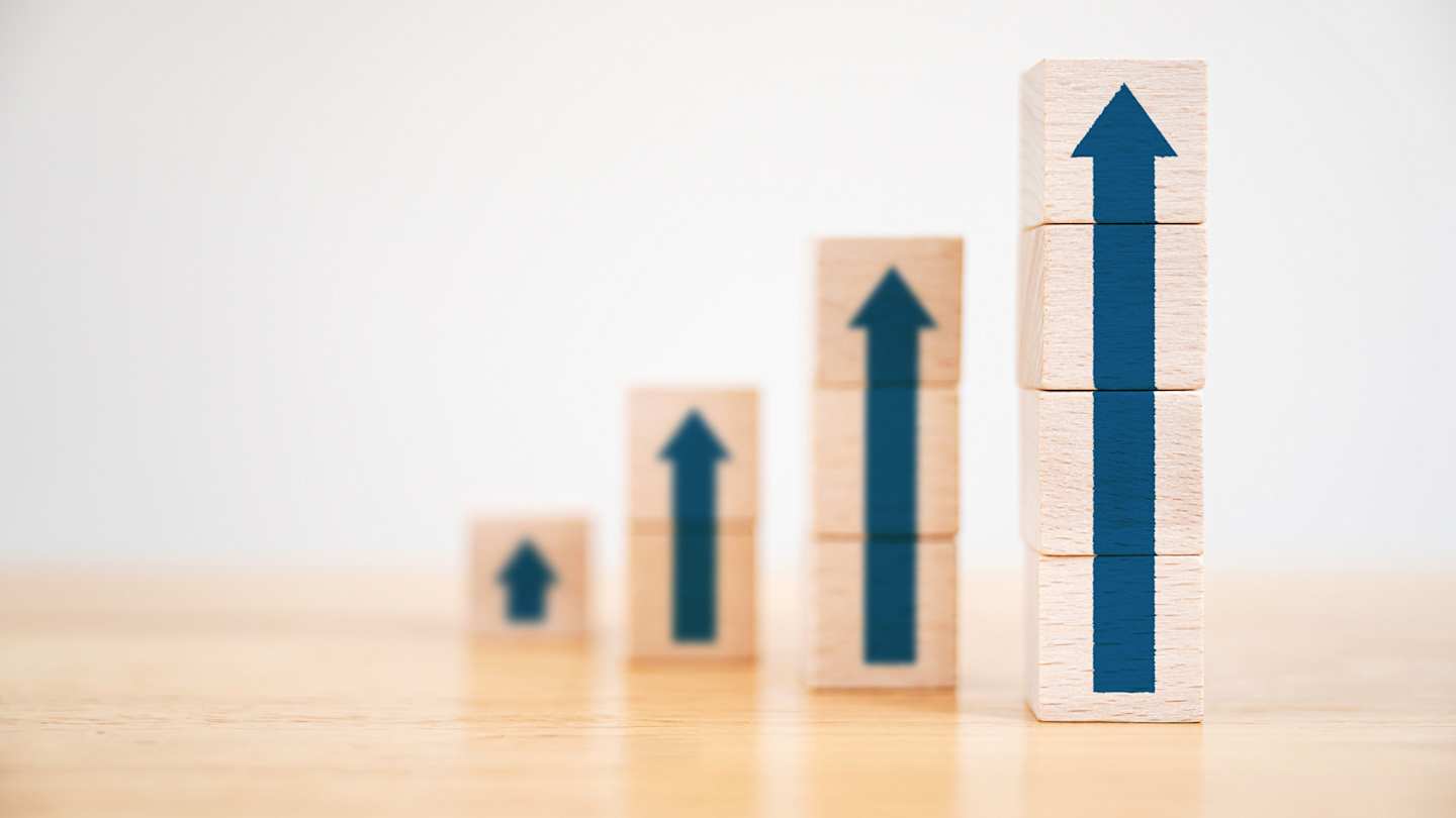Wooden blocks with arrows pointing upwards, stacked to signify the maximising of sales for hosts