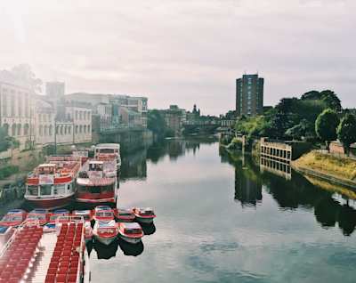 Small boats docked on the River Ouse city on a sunny day, York, England, UK
