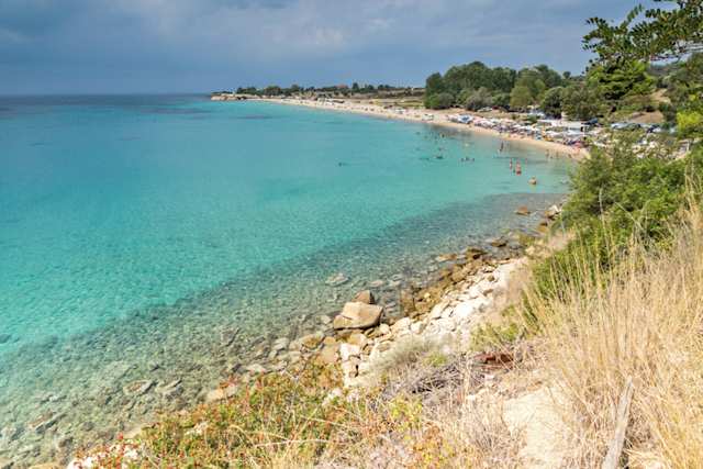 A panoramic view of clear blue sea by a strip of sand at Agios Ioannis Beach, Halkidiki, Greece