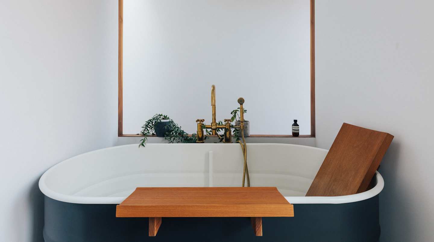 A large bath tub with luxurious wooden accessories in a bathroom
