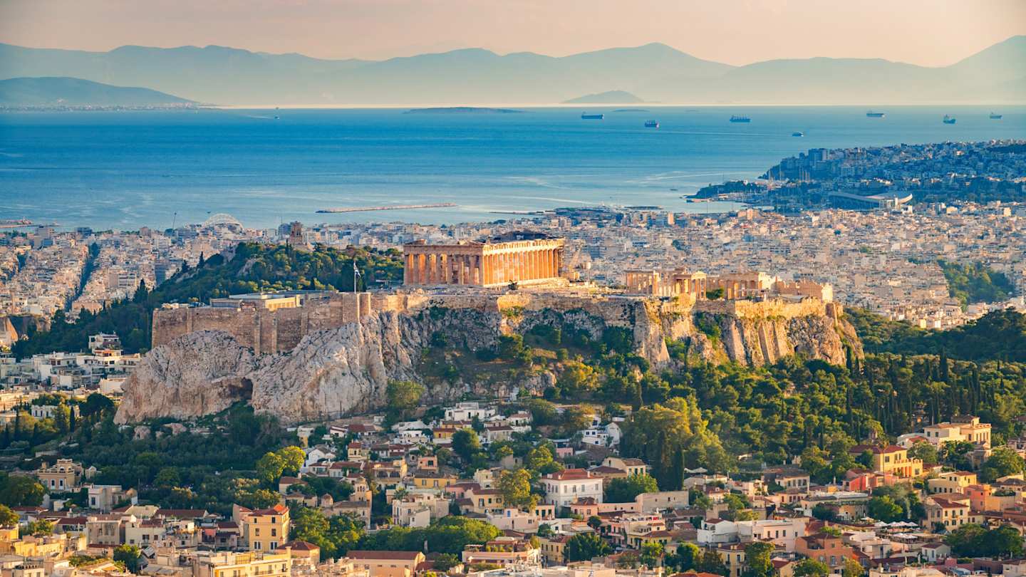 An aerial view of the Acropolis on a tall cliff above the city of Athens, Greece