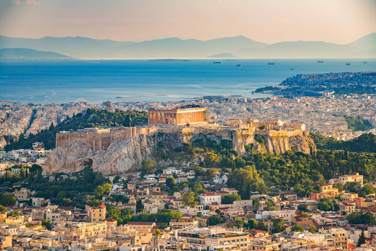 An aerial view of the Acropolis on a tall cliff above the city of Athens, Greece