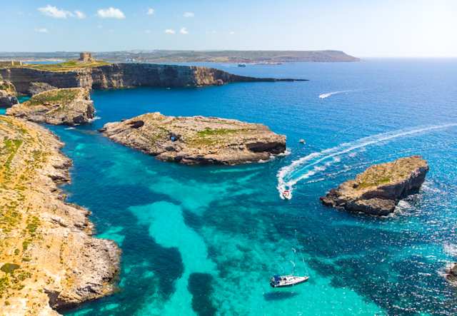 An aerial view of Comino island and boats on the sea, Malta