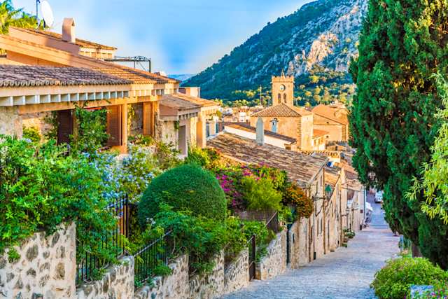 A narrow street with rows of cottages and colourful plants, Majorca, Spain