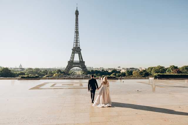 A couple by the Eiffel Tower on their wedding day in Paris