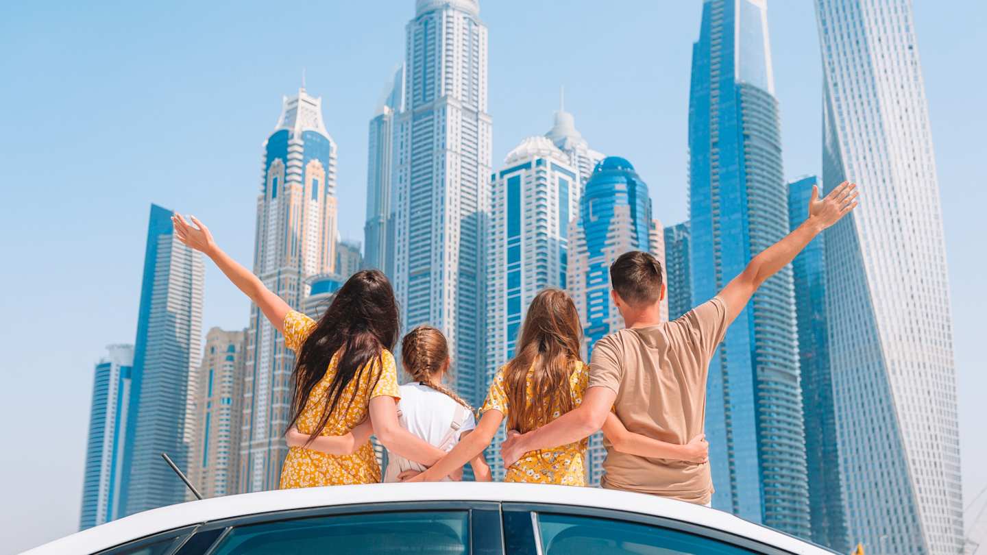 A young family looking at skyscrapers on a sunny day in Dubai, UAE