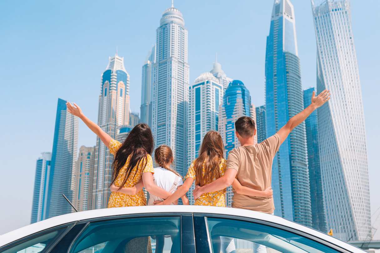 A young family looking at skyscrapers on a sunny day in Dubai, UAE