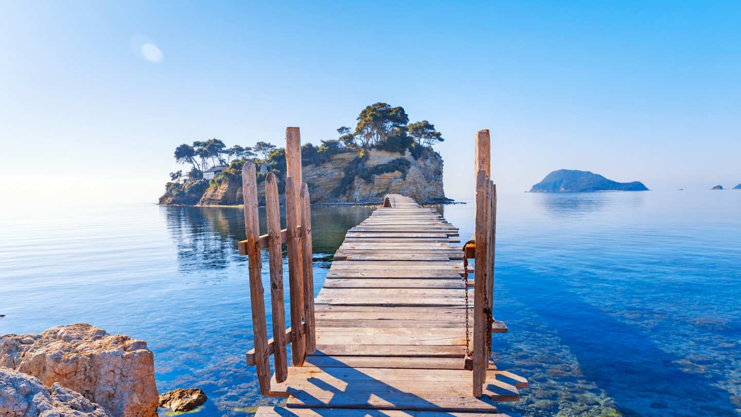 A small wooden gate on a bridge leading to a small island over the sea from Zakynthos, Greece
