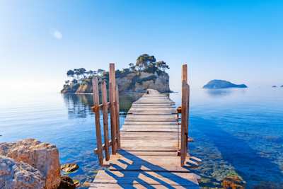 A small wooden gate on a bridge leading to a small island over the sea from Zakynthos, Greece