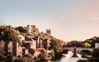 A view of houses and a cathedral next to the River Wear in Durham, England, UK