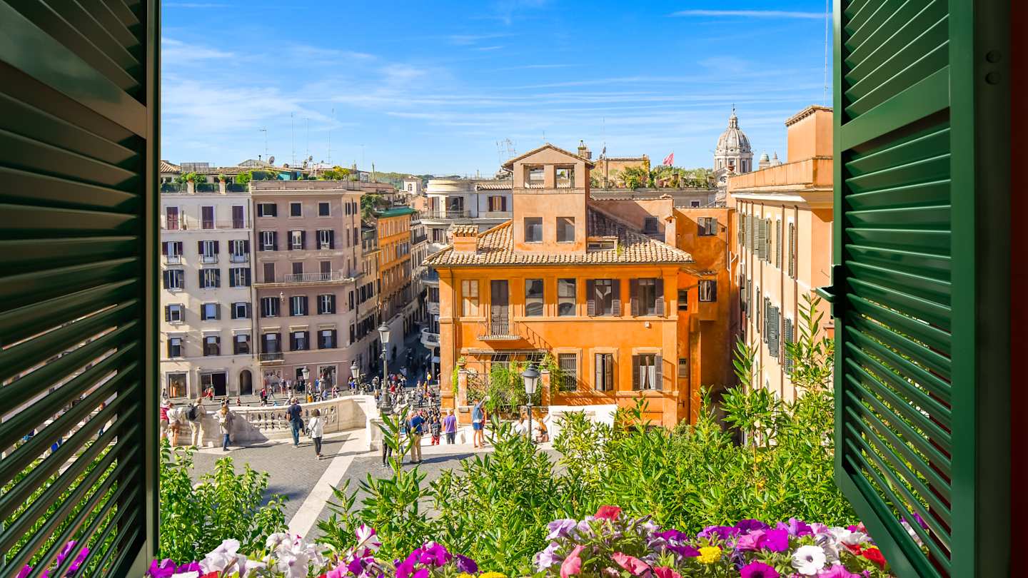 View through an open window with green shutters overlooking the Spanish Steps and the Piazza di Spagna in Rome, Italy
