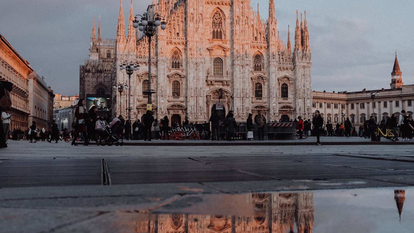 A view of the Duomo behind a crowd of people at sunset, Milan, Italy