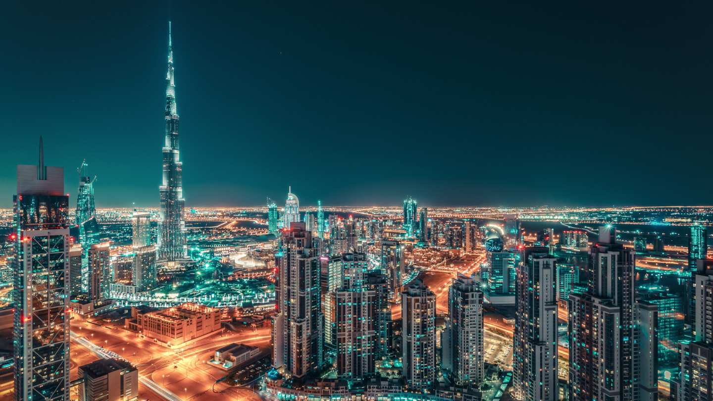An aerial view of the city skyline lit up at night, Dubai, UAE