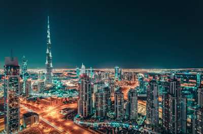 An aerial view of the city skyline lit up at night, Dubai, UAE