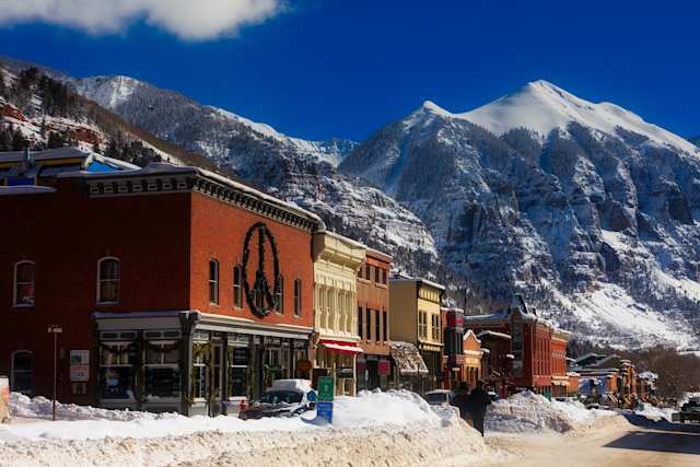A red brick building in front of snow-capped mountains in Telluride Town Centre, Colorado, US