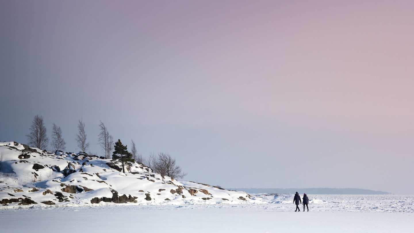 Two people strolling through large amounts of snow, Finland