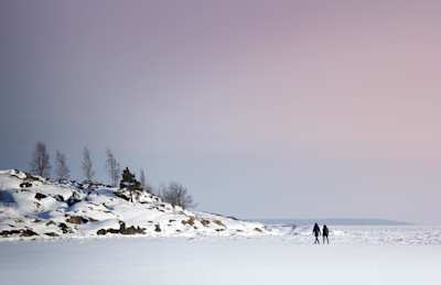 Two people strolling through large amounts of snow, Finland