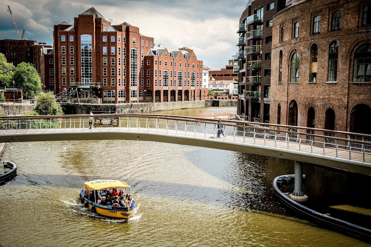 A boat sailing under a bridge at Bristol Harbour, UK