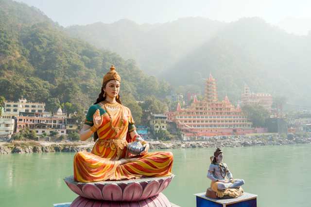 Statues of sitting goddess Parvati and Shiva on the riverbank of Ganga, Rishikesh, India