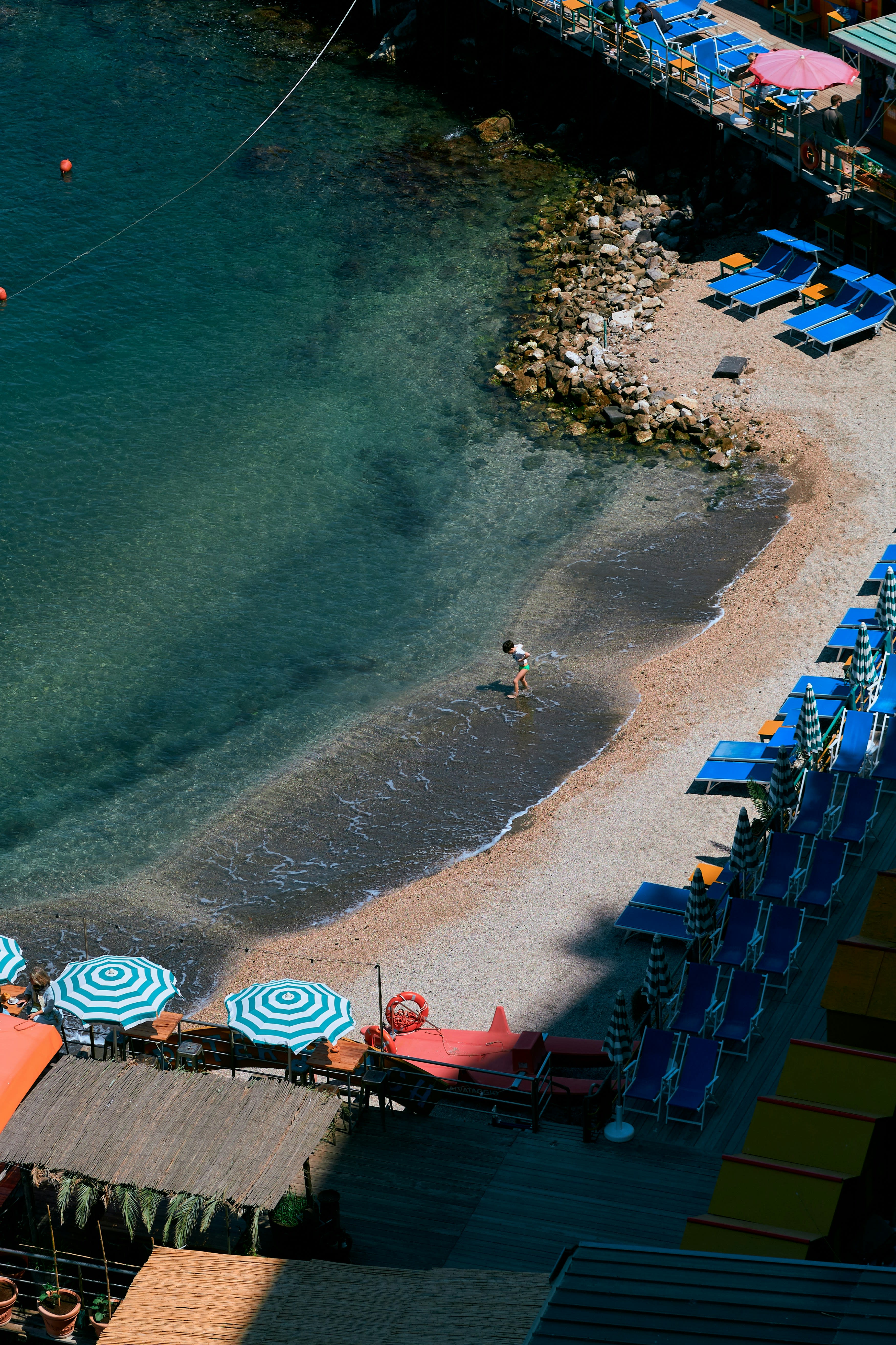 A very cosy and quiet beach in Sorrento with colourful striped umbrellas.