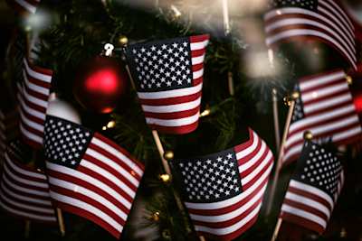 Small USA flags in front of a Christmas tree
