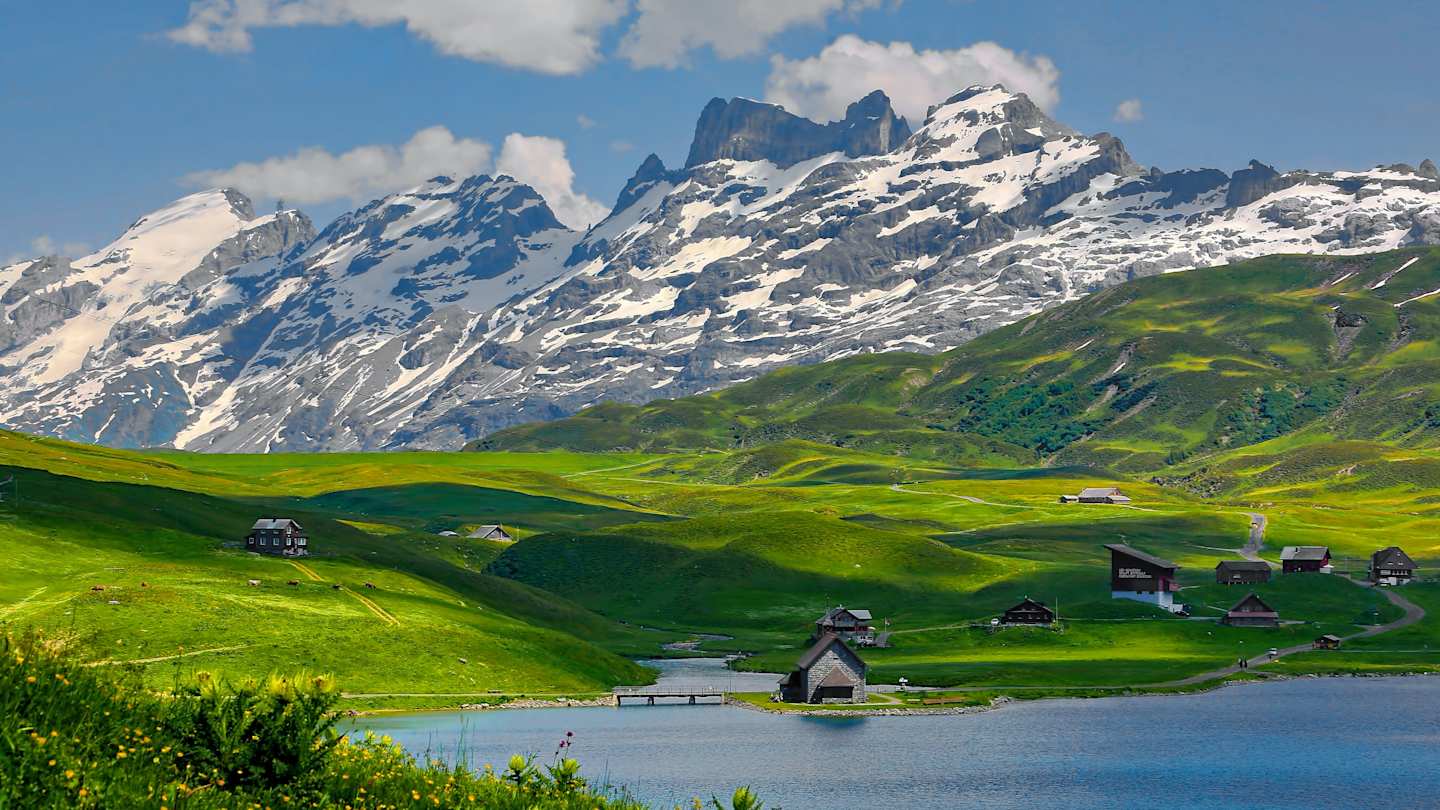 Cabins in front of green fields and large mountains in Kerns, Switzerland