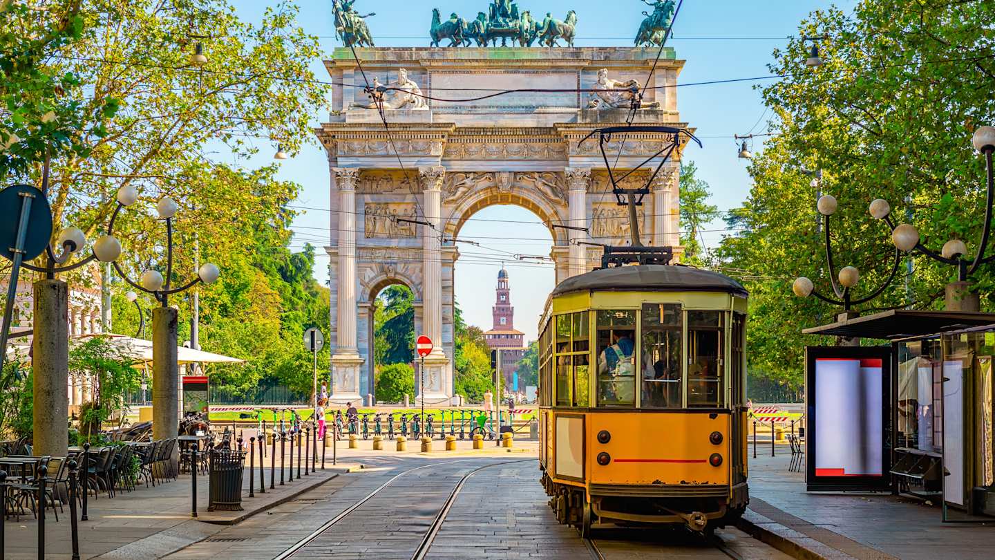 Yellow vintage tram in front of the Arco della Pace (Peace Arch) in Milan, Italy